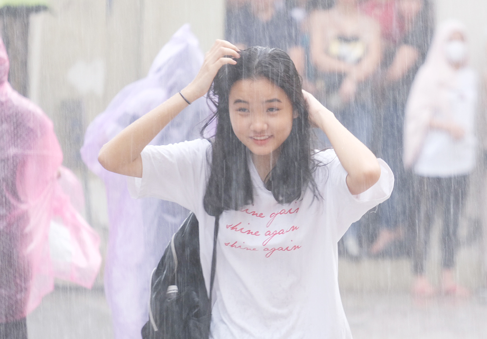 Thí sinh đội mưa tìm phòng thi sáng 4/7. Ảnh: Dương Tâm.